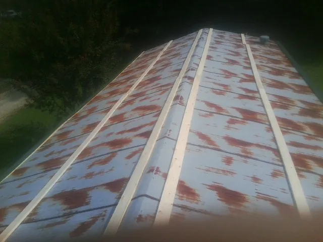 Rusted metal roof panels with new wood purlins before replacement — Storm Damage Roof Repair in North East by Roofing Brothers