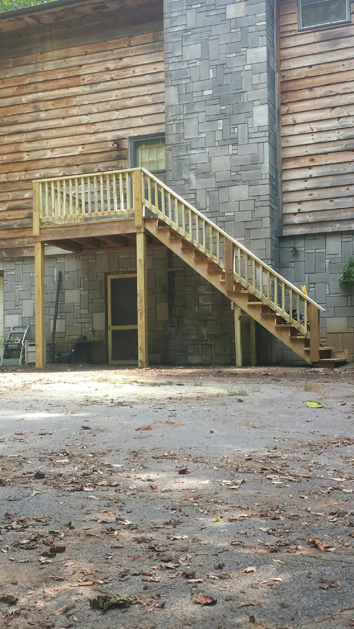New pressure treated deck and stair landing on a log home in North East
