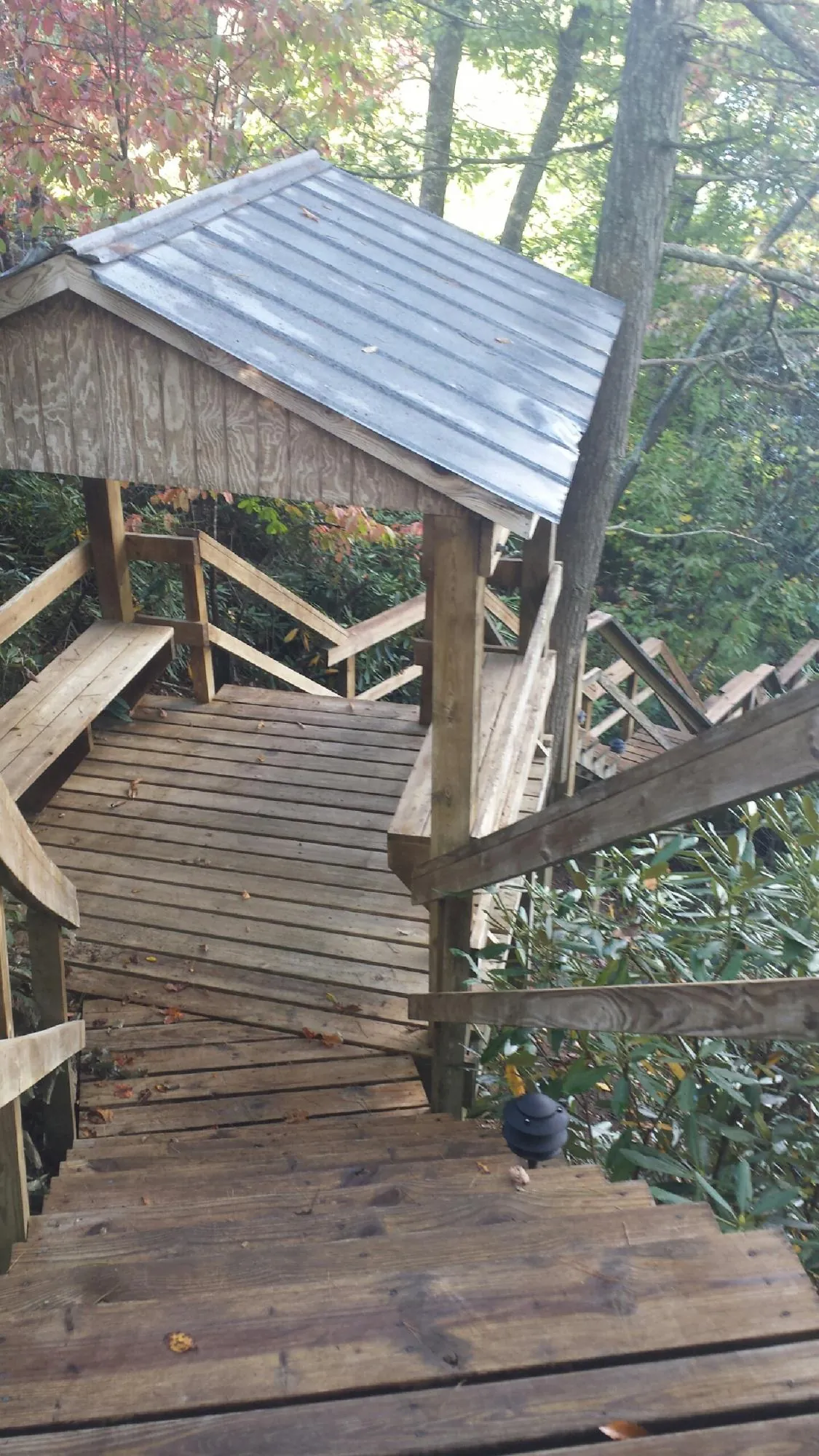 Metal roofed shelter over wooden steps on a wooded walkway — Skylight Repair & Installation work by our crew in North East