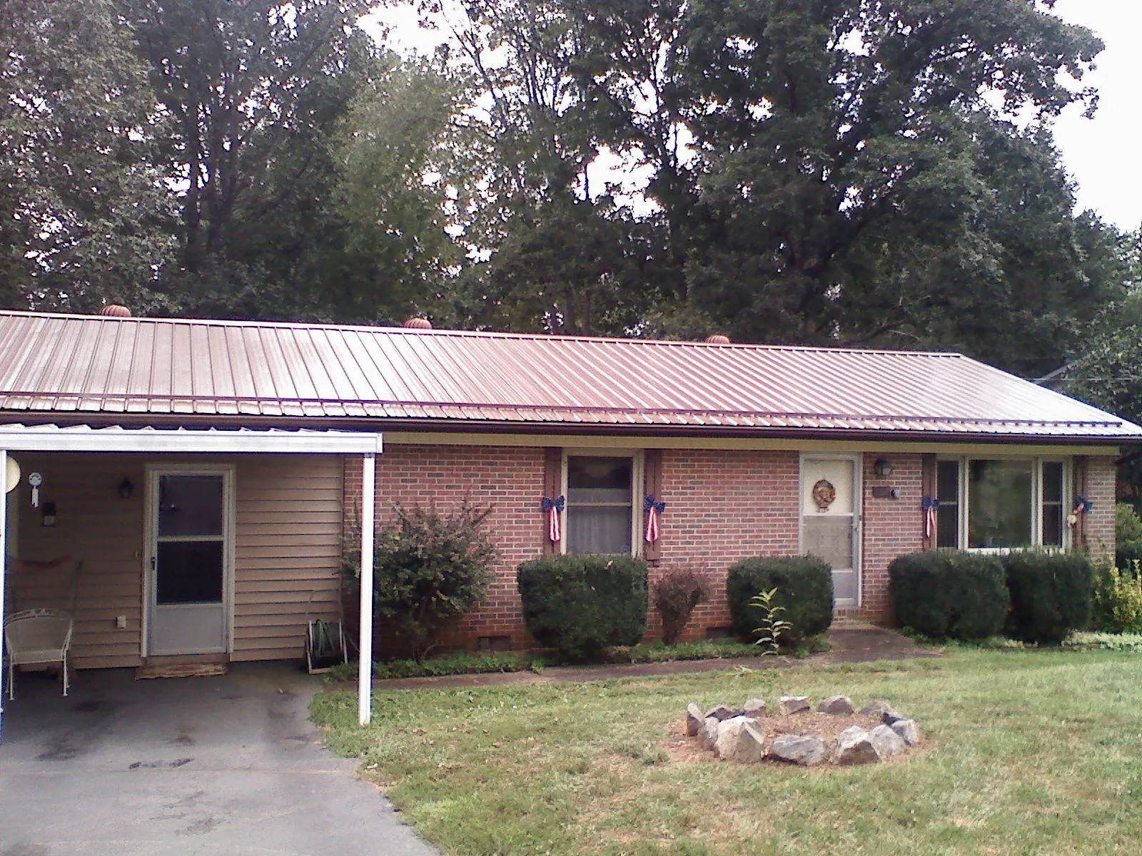 Bronze metal roof and carport on a brick ranch home — Roof Repair work by our crew in North East